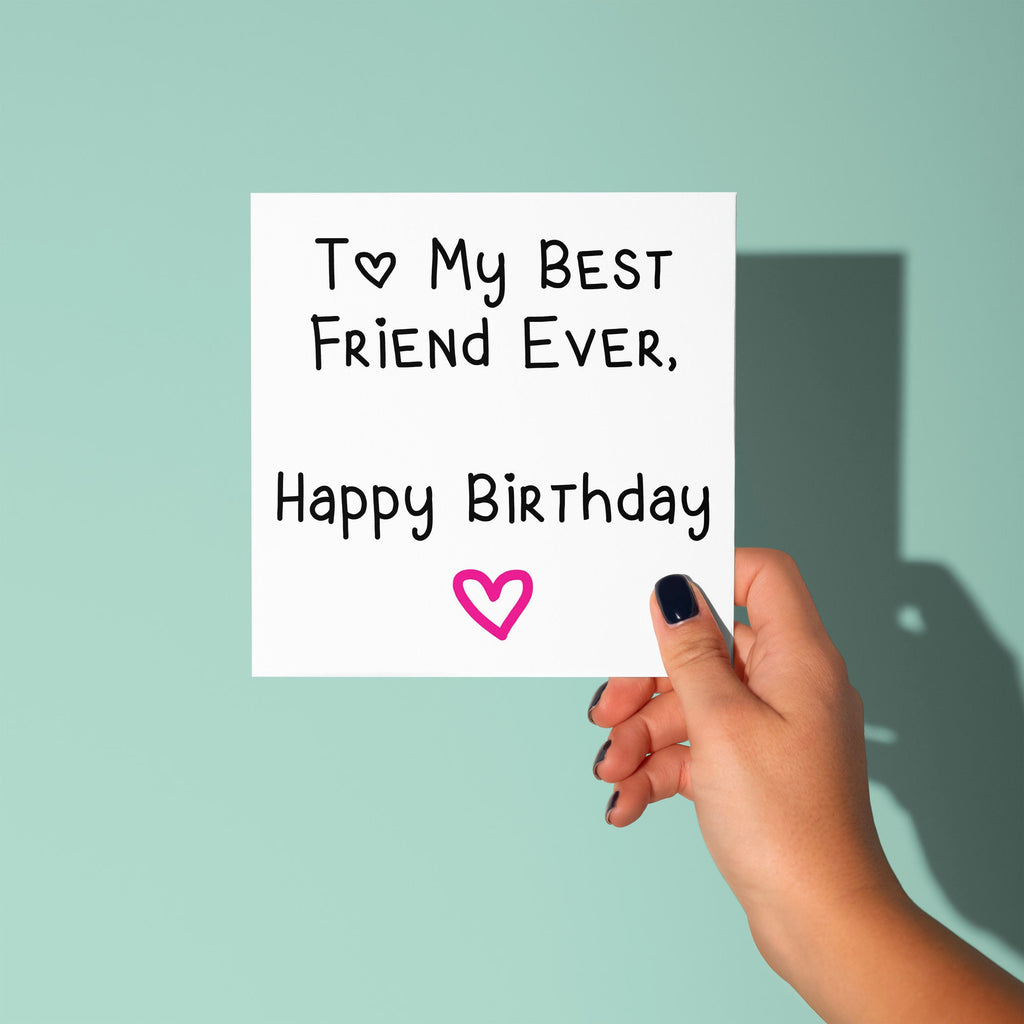Hand holding a card with 'Happy Birthday' message on a light green background